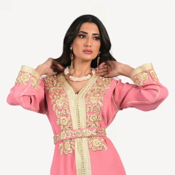 Vue complète du Caftan Saloua, caftan marocain rose raffiné avec broderies dorées, conçu pour occasions spéciales.