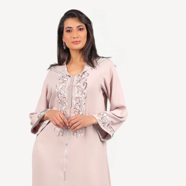 Djellaba Dana Mautassin rose nude, confectionnée à la main en crêpe fluide avec broderies raffinées, une tenue artisanale chic et intemporelle.