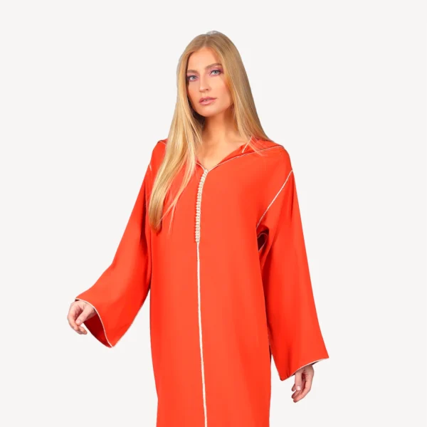 Djellaba Ghala Mautassin orange vibrant, en crêpe léger avec détails en berchman raffiné, une tenue élégante et festive.