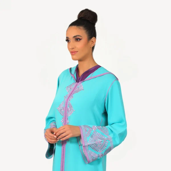 Djellaba Maysa Mautassin en bleu turquoise, confectionnée en crêpe avec dentelle et broderies délicates, une pièce artisanale élégante.