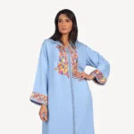 Broderies délicates et finitions sophistiquées sur la Djellaba Reem bleue en crêpe, une tenue artisanale élégante.