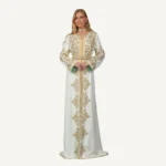 Une somptueuse robe blanche en crêpe ornée de broderies dorées et de perles raffinées. Idéale pour les mariages et les cérémonies, elle incarne l'élégance et la tradition.